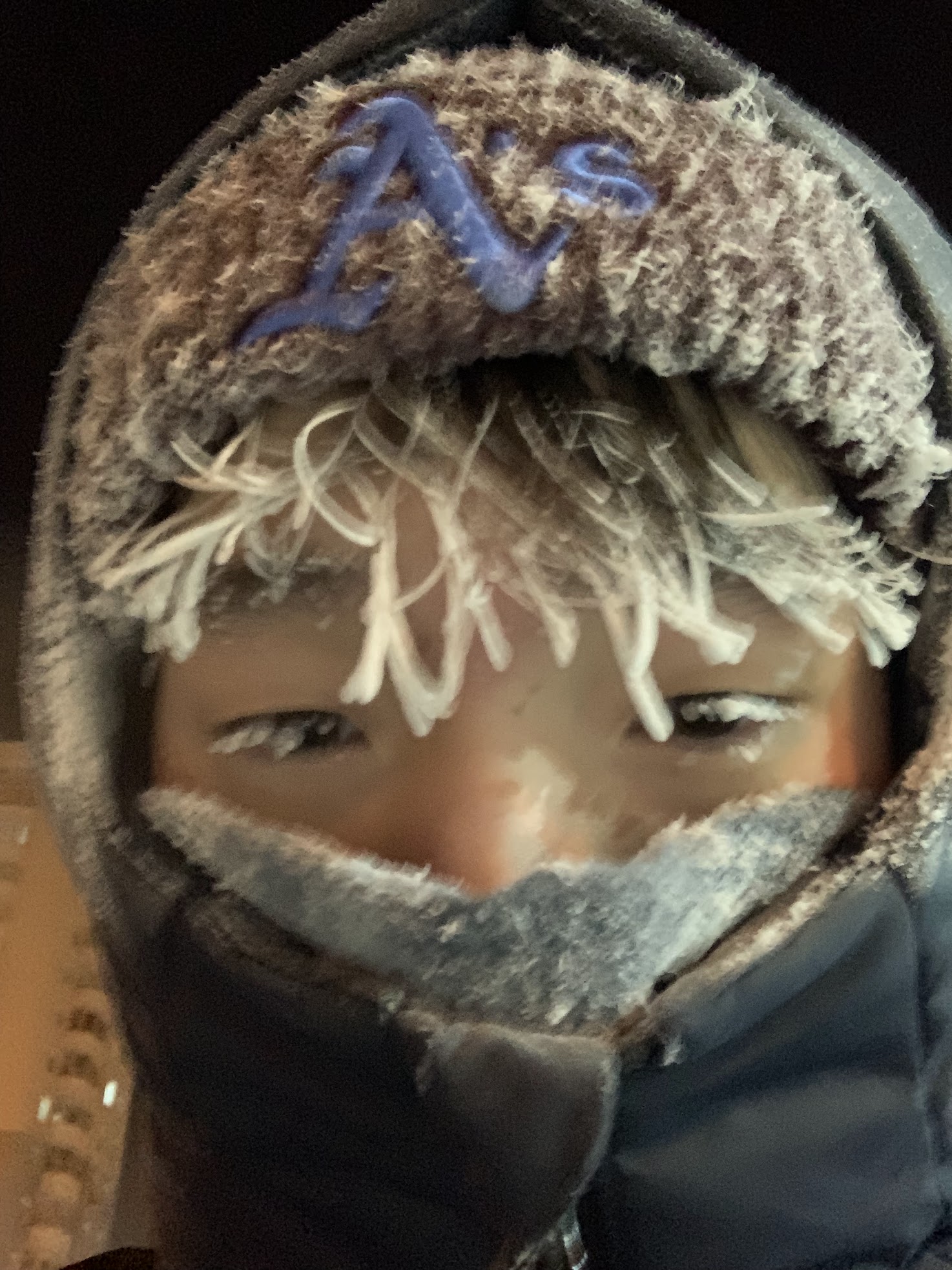 Aisen bundled up in a winter hat and scarf, with frost on his eyelashes.