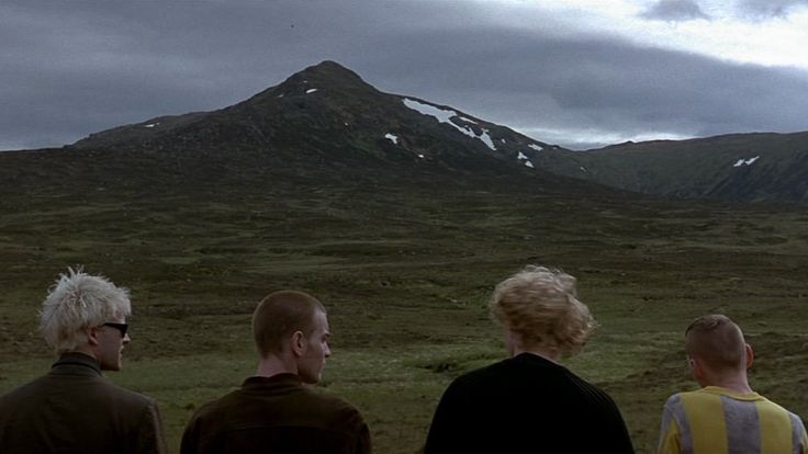 Friends look out over the mountains of the Scottish Highlands.